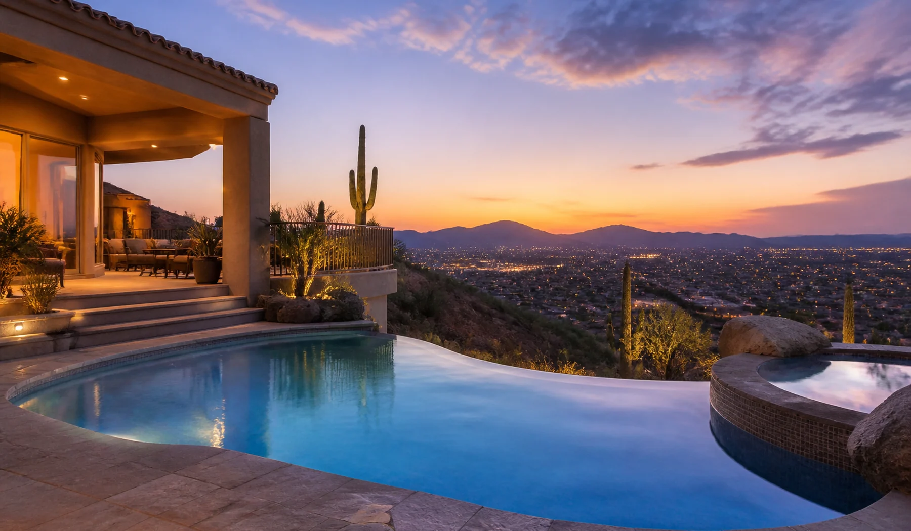 Fountain Hills pool glowing at blue hour with desert hills beyond the yard