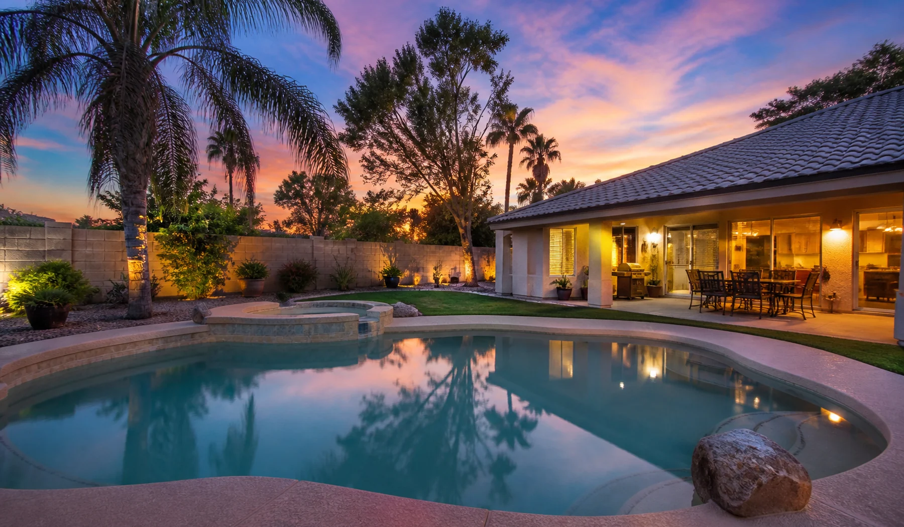 Phoenix backyard pool glowing at sunset beneath a desert sky